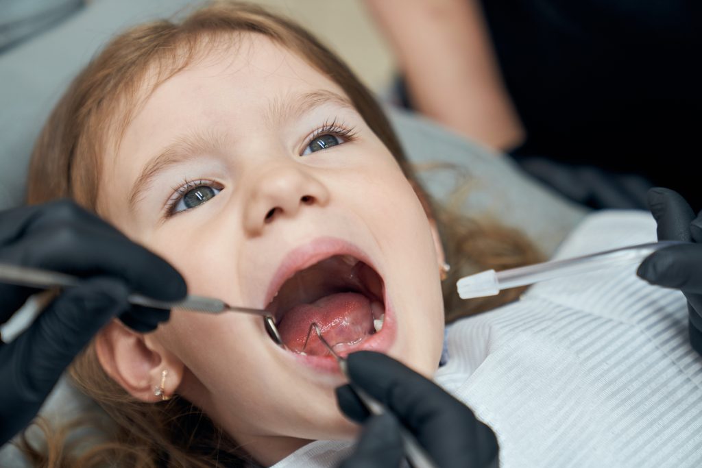 Dentist pentru copii explicând tratamentul unui pacient mic în cabinetul STOMESTET Cluj