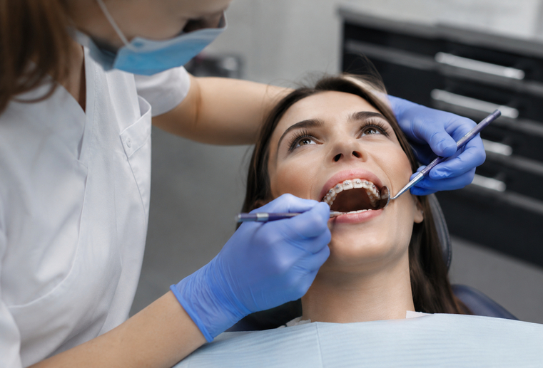 Medic stomatolog efectuează detartraj unui pacient cu aparat dentar la STOMESTET Cluj