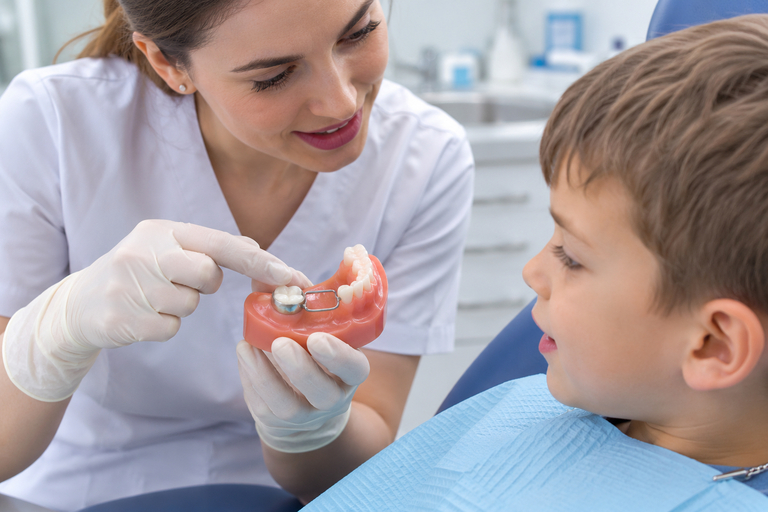 Medic stomatolog consultă un copil pentru un menținător de spațiu dentar la STOMESTET Cluj-Napoca
