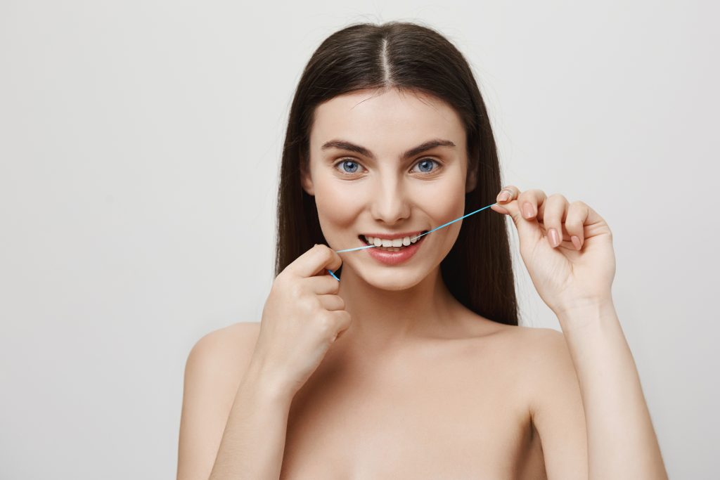 Folosirea corectă a aței dentare pentru curățarea dintre dinți